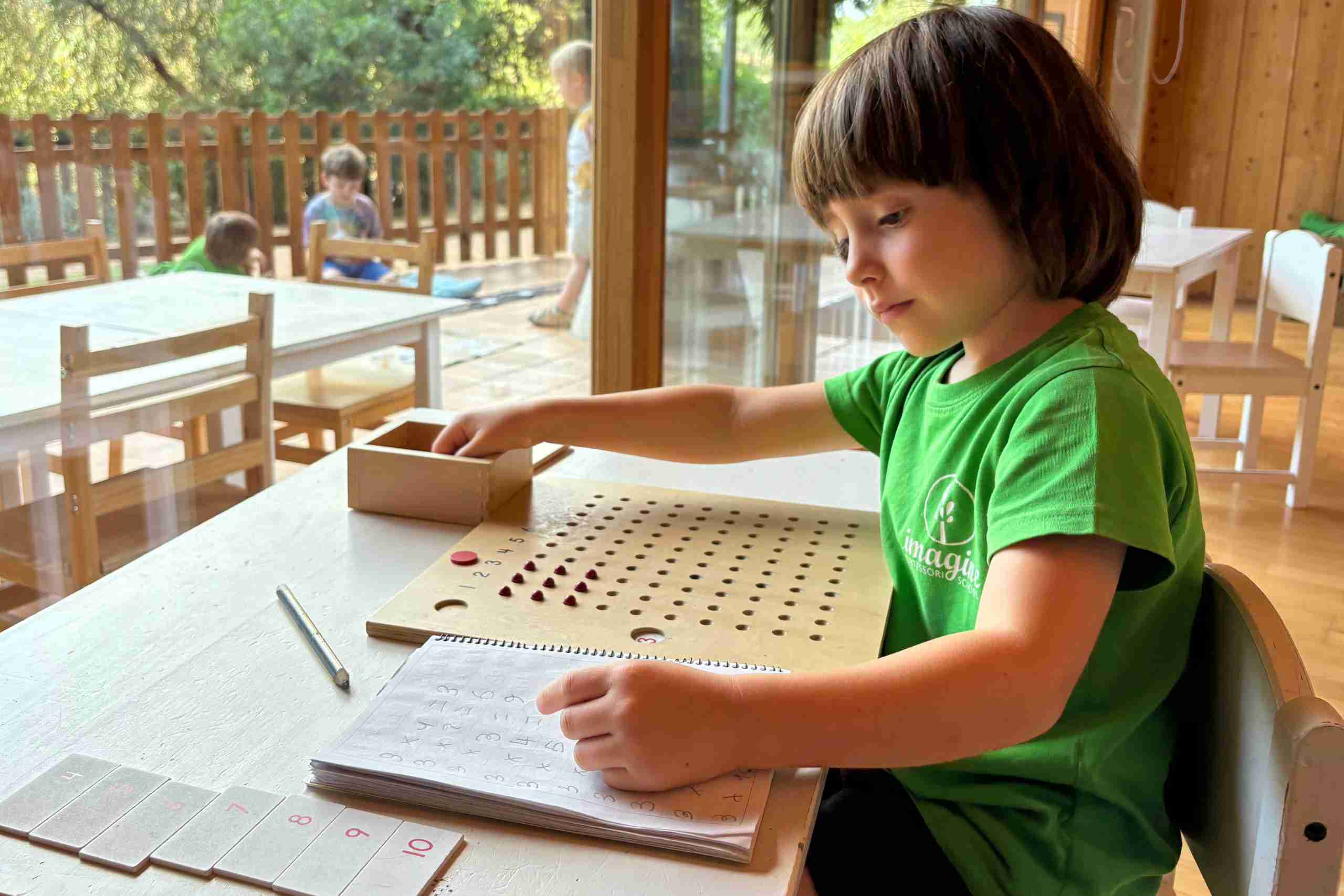 Niño aprendiendo con materiales Montessori en Imagine Montessori School Valencia.